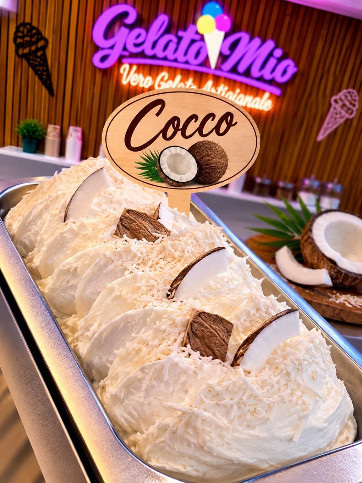 Bak wit kokosgelato met kokosschaafsel en stukken verse kokosnoot